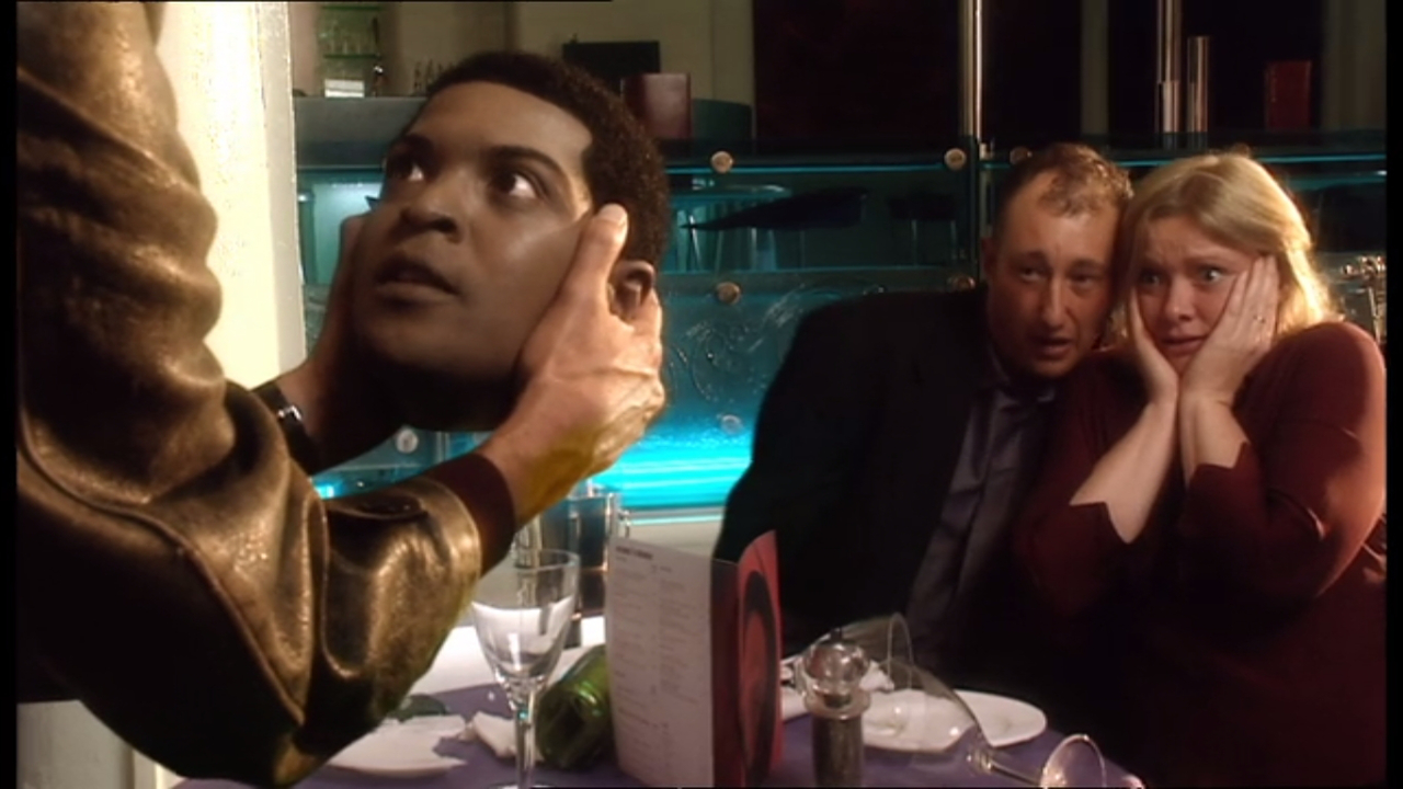 Kadr z odcinka "Rose": głowa fałszywego Micky'ego Smitha (Auton) w rękach Dziewiątego Doktora